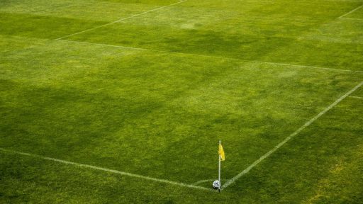 White and Black Soccer Ball on Side of Green Grass Field during Daytime