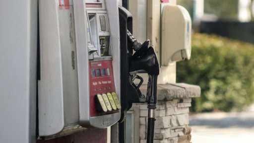 a gas pump next to a brick wall