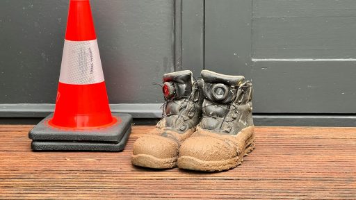 A pair of shoes sitting next to a traffic cone