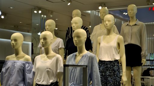 Kledingrekken met zomerartikelen in de uitverkoop in een winkel
