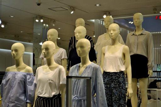 Kledingrekken met zomerartikelen in de uitverkoop in een winkel