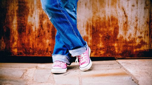 Vrouwelijke winkelmedewerker die staat op een harde winkelvloer met werkschoenen aan