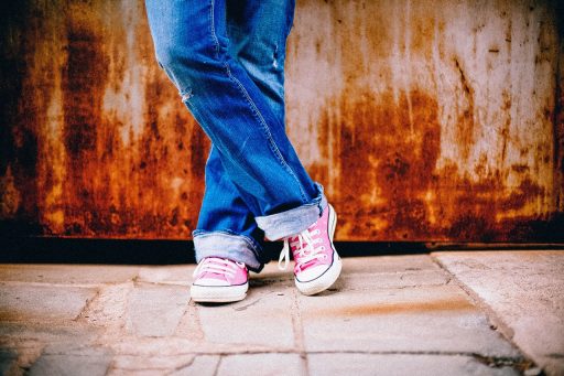 Vrouwelijke winkelmedewerker die staat op een harde winkelvloer met werkschoenen aan
