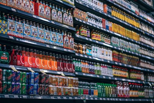 Een stagiair in een winkel die producten opstelt onder begeleiding van een winkeleigenaar