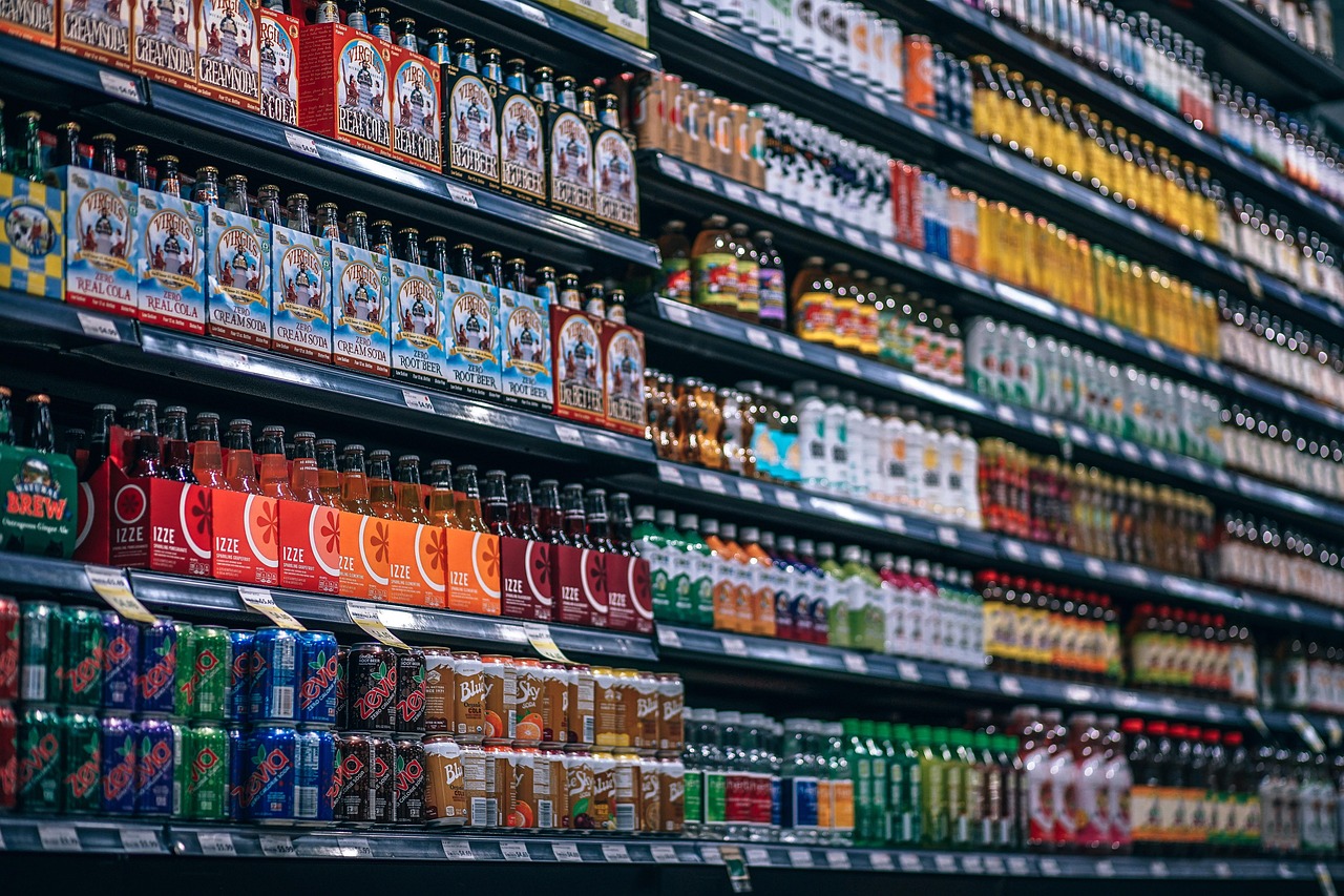 Een stagiair in een winkel die producten opstelt onder begeleiding van een winkeleigenaar