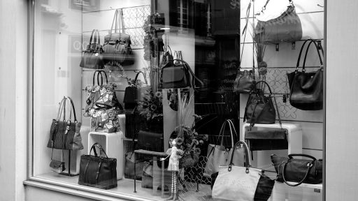 Wandpresentatie van parfumflesjes en cosmetica in een moderne winkel