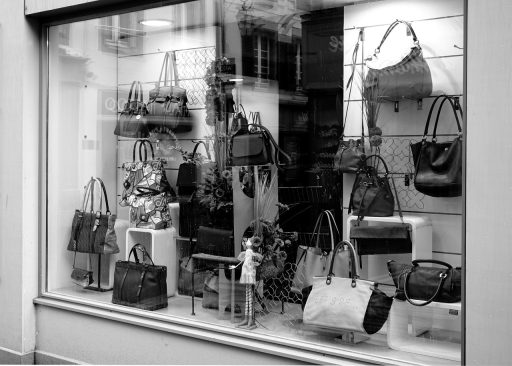 Wandpresentatie van parfumflesjes en cosmetica in een moderne winkel