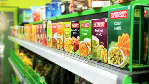 Kassamedewerker helpt klant bij het controleren van productinformatie in een supermarkt