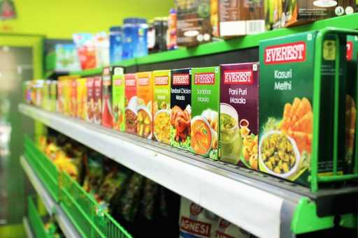Kassamedewerker helpt klant bij het controleren van productinformatie in een supermarkt