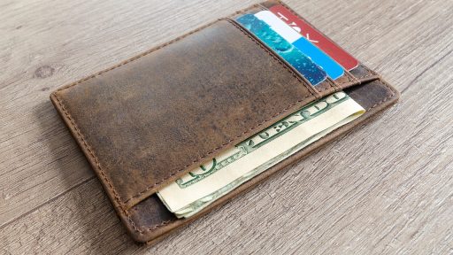 Retailmedewerker telt bankbiljetten aan de kassa van een winkel