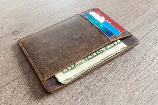 Retailmedewerker telt bankbiljetten aan de kassa van een winkel